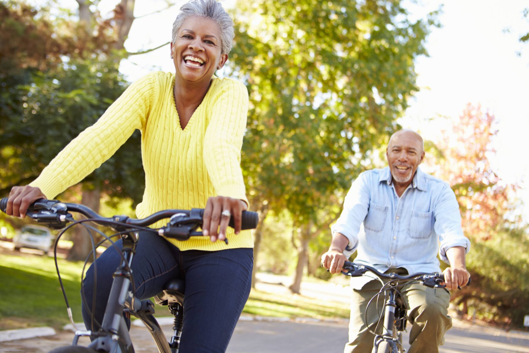 happy couple riding bikes down the street