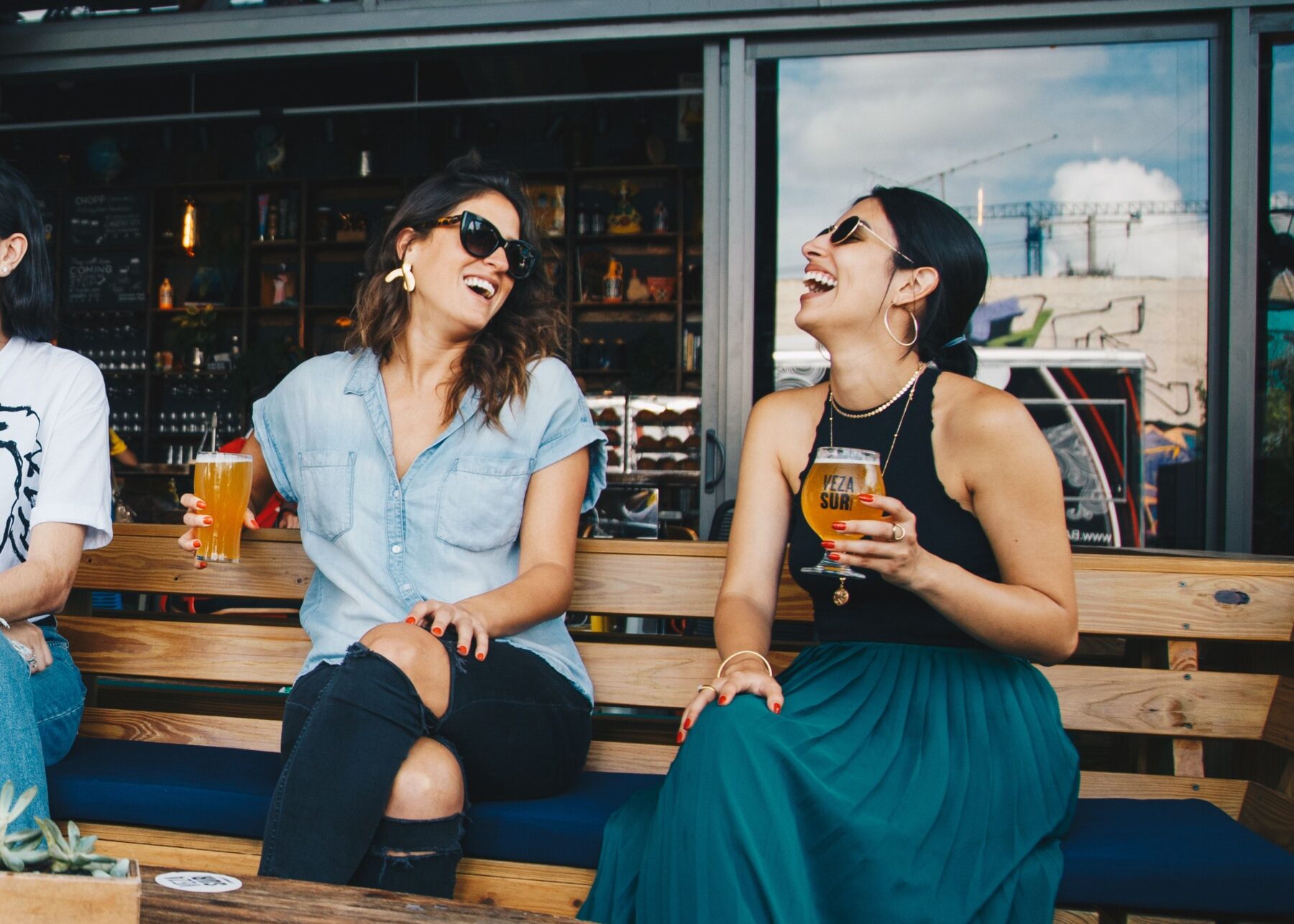 friends sitting at an outdoor patio enjoying drinks and laughing