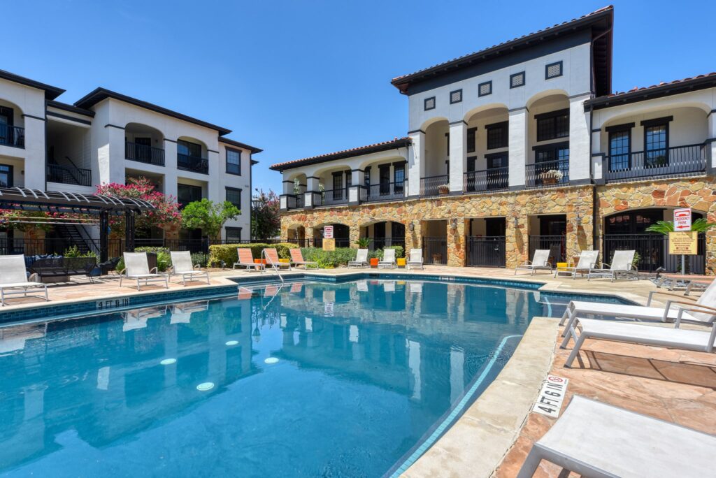 Community pool with lounge chairs at San Miguel apartments for rent in San Antonio, TX